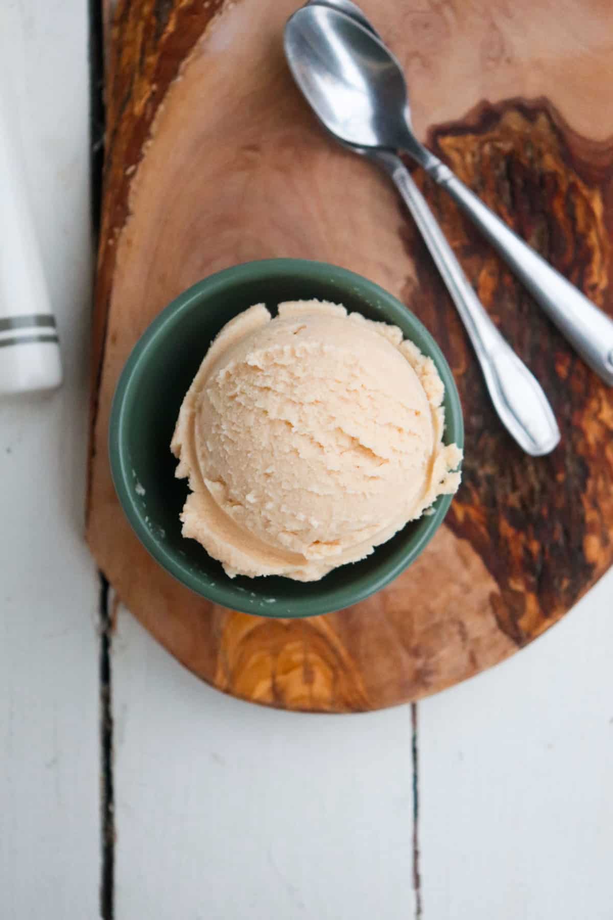 scoop of ninja creami peanut butter ice cream on a wooden board.