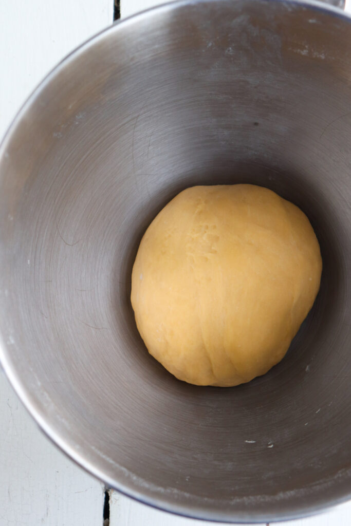 smooth dough in metal bowl.