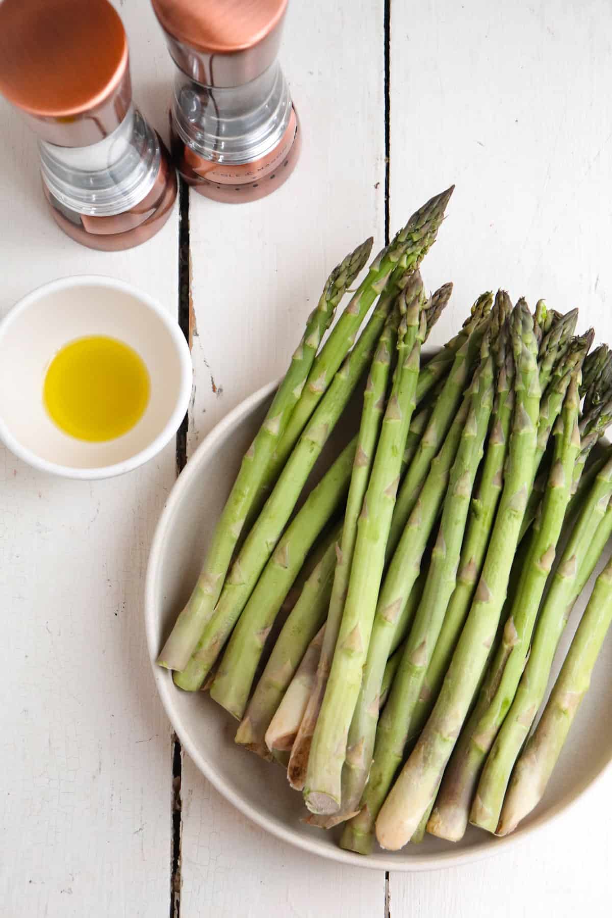 ingredients for air fryer asparagus on a white background.