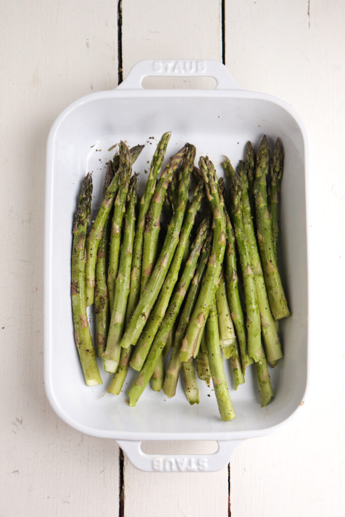 trimmed asparagus spears in white dish.