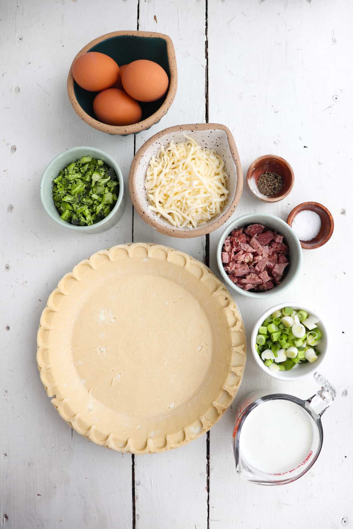 ingredients for ham and broccoli quiche on a white background.