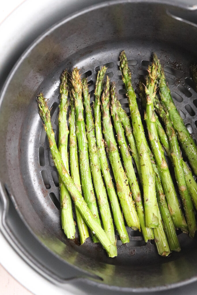 cooked asparagus in ninja foodi air fryer basket.