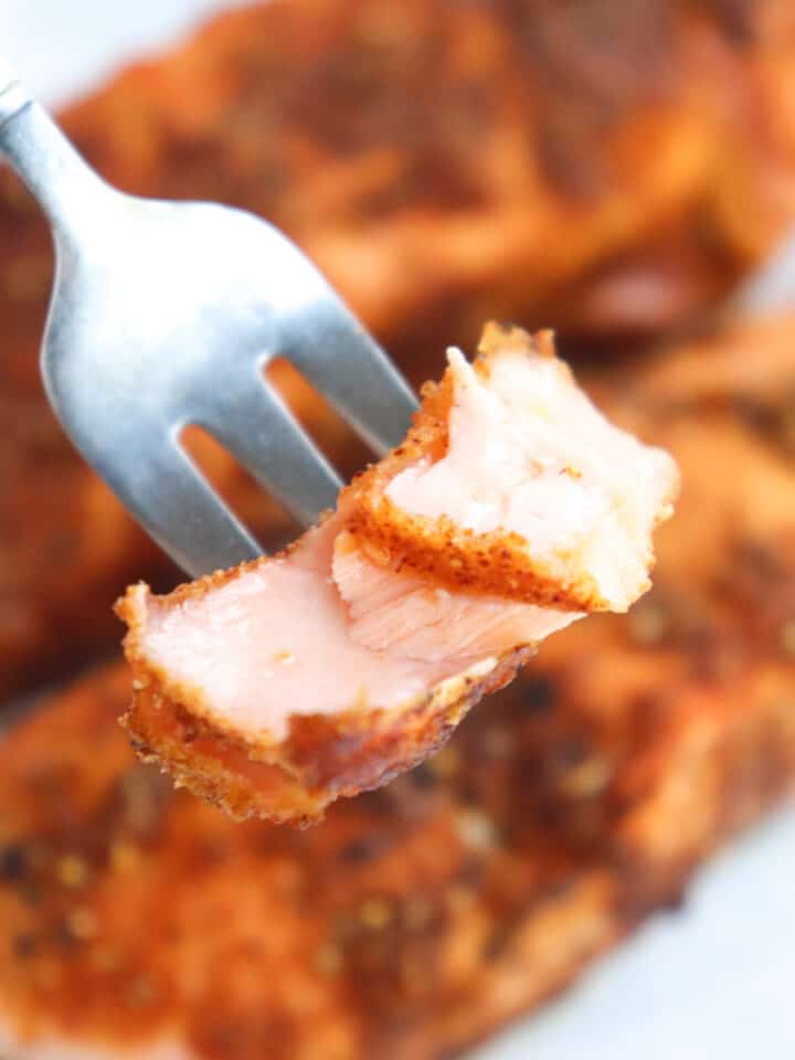 fork holding up bite of salmon.