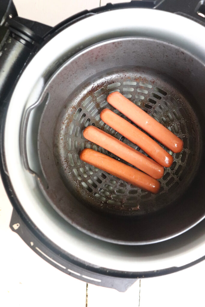 hot dogs placed in ninja foodi basket.