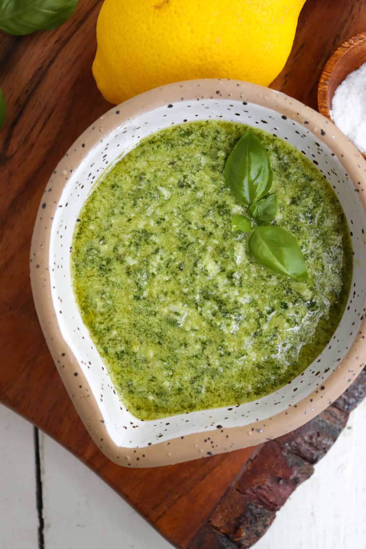 small bowl of finished pesto garnished with basil.