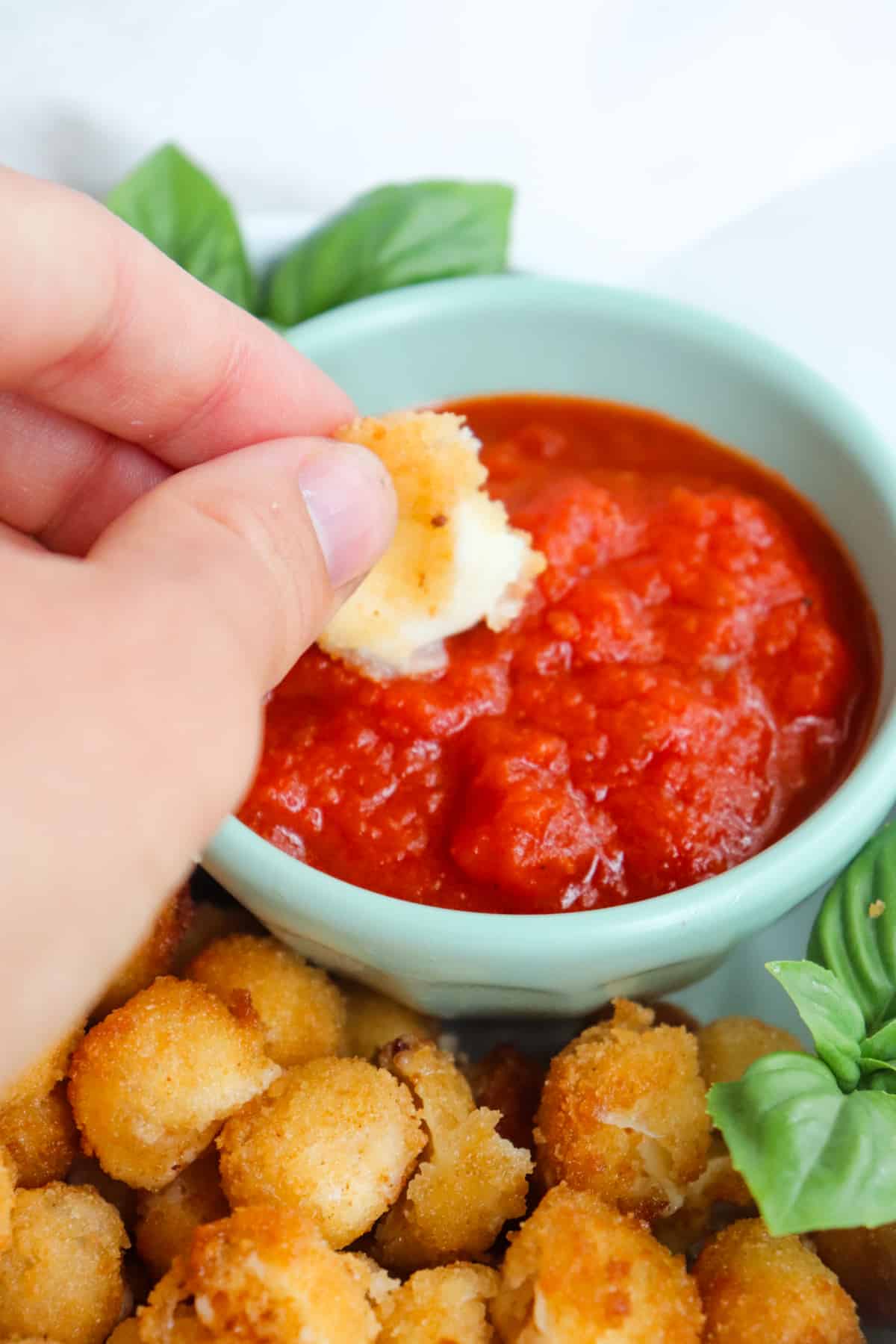 mozzarella ball that is being dipped in marinara sauce.
