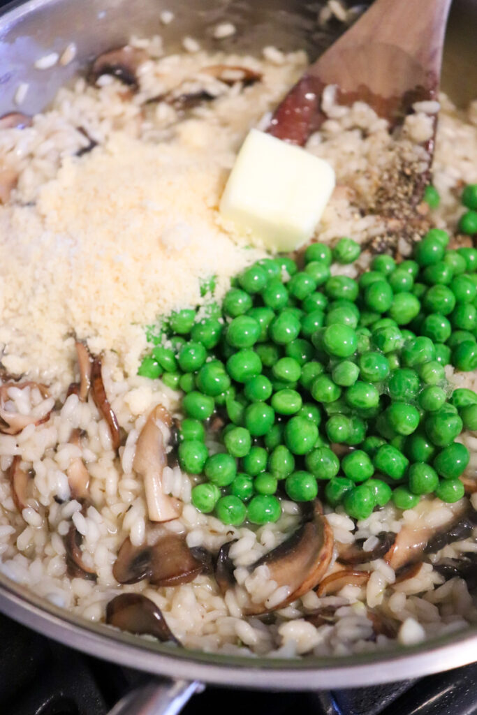 peas being added to mushroom risotto.