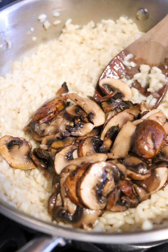 cooked mushrooms being added back into risotto.