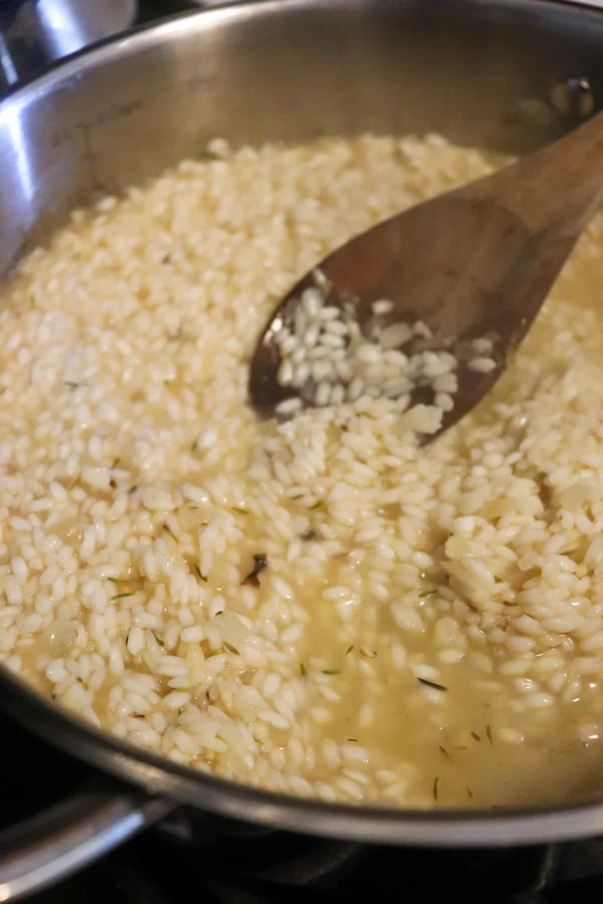 spoon stirring broth into rice.
