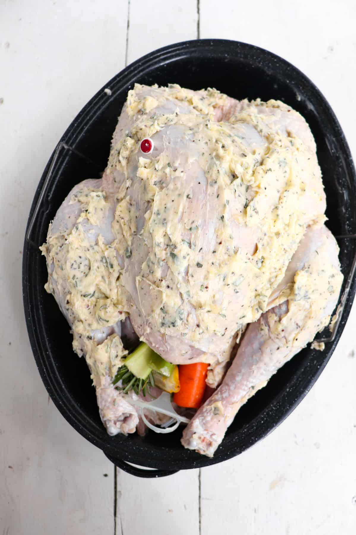 raw turkey covered in compound butter.
