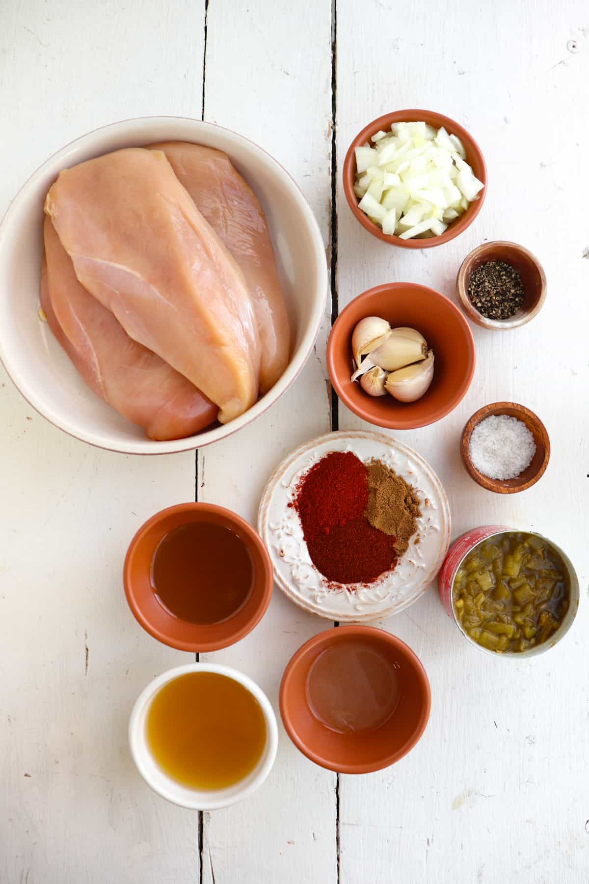 ingredients for green chile chicken laid on out table.