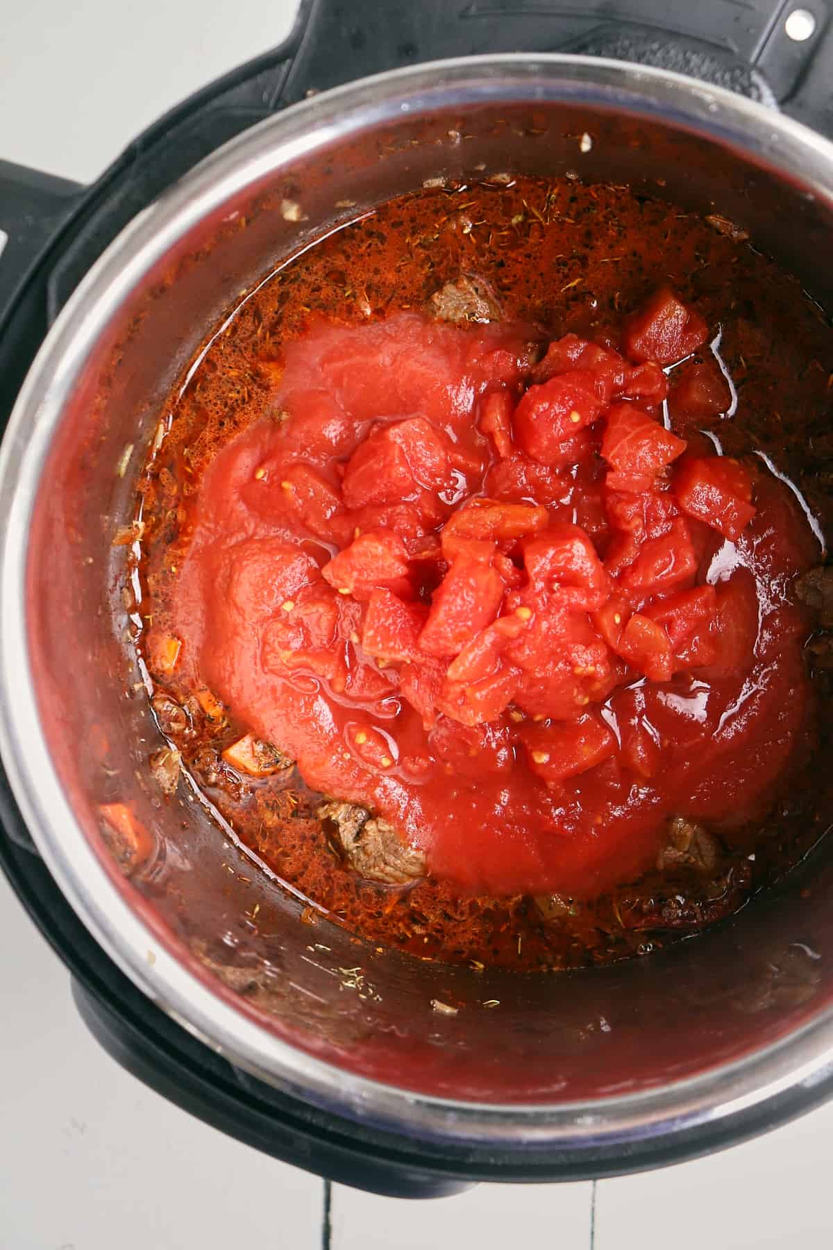 tomatoes and tomato sauce added to instant pot but not stirred.