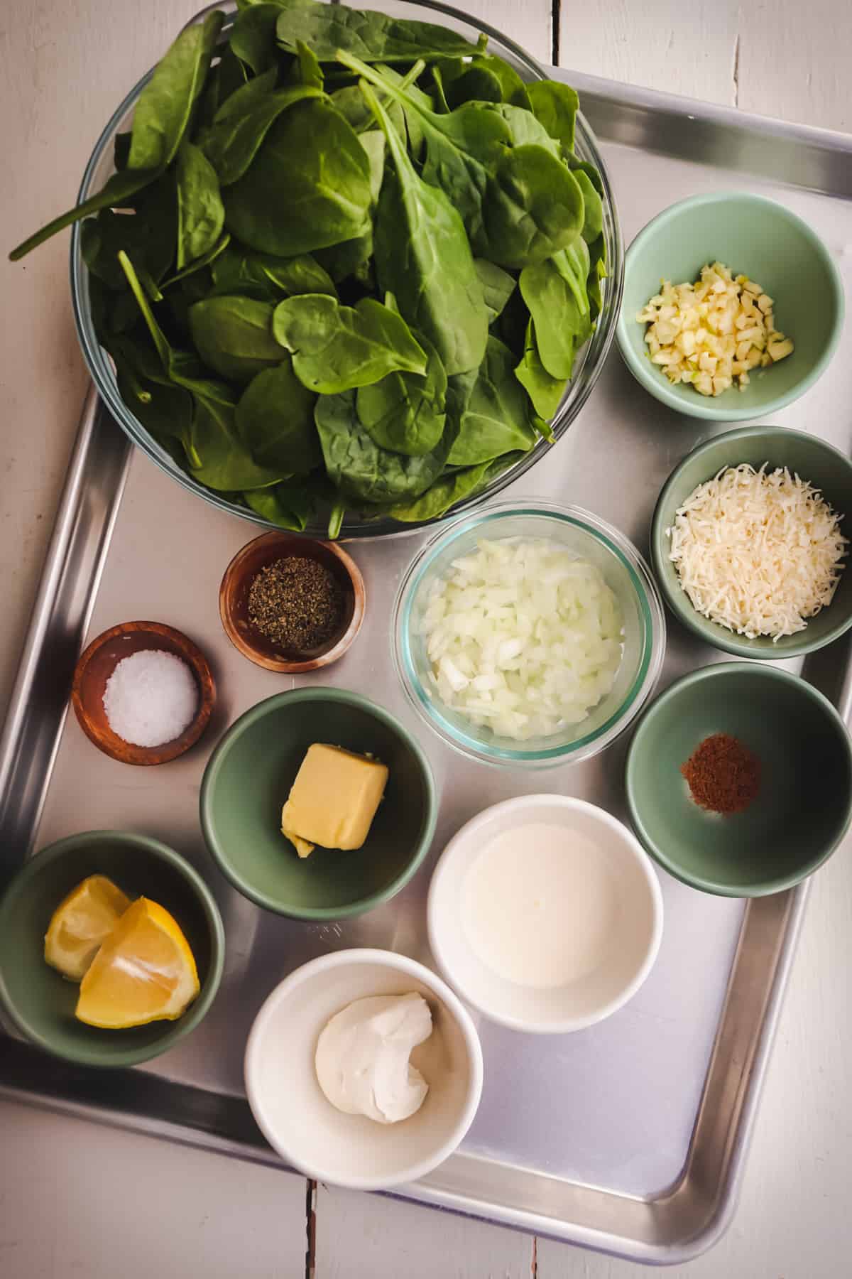 ingredients for creamed spinach on a metal sheet pan.