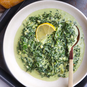 steakhouse style creamed spinach in a bowl with a lemon garnish.