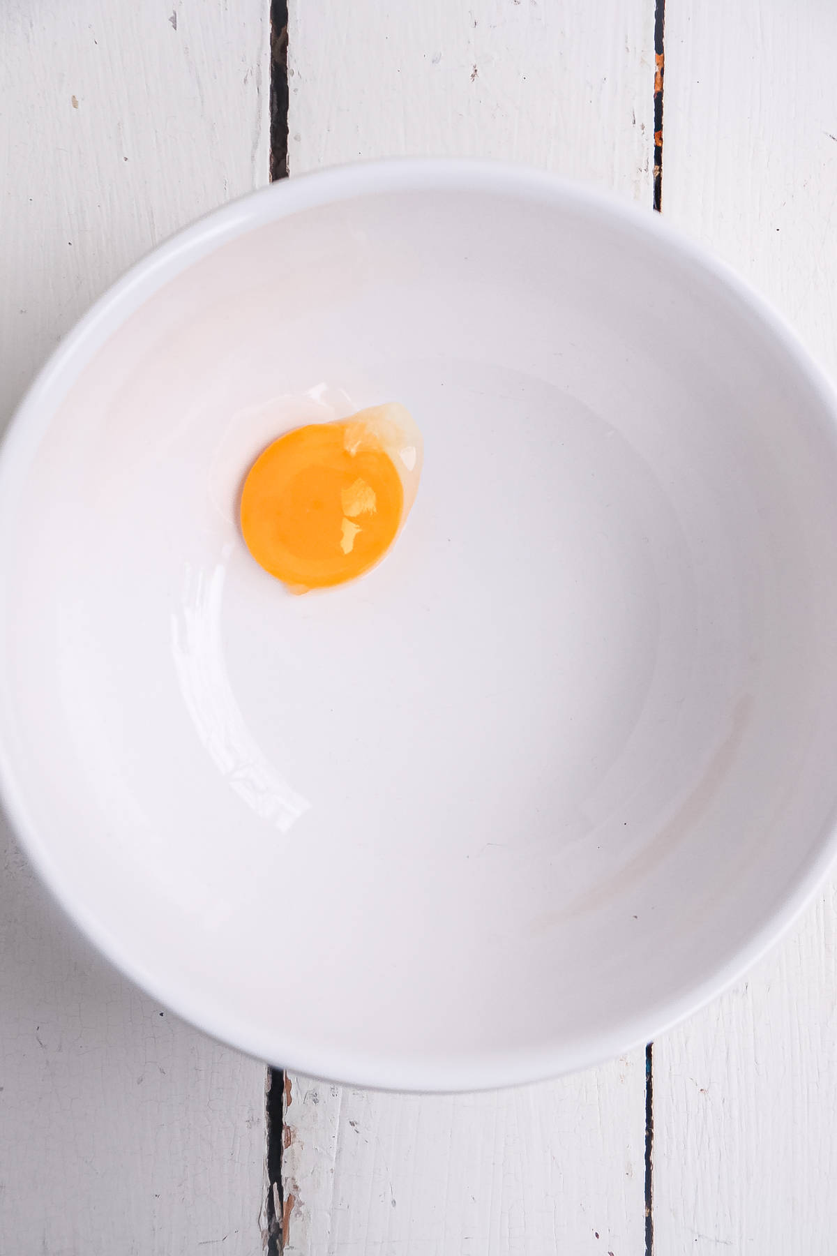 one egg yolk in a white bowl.
