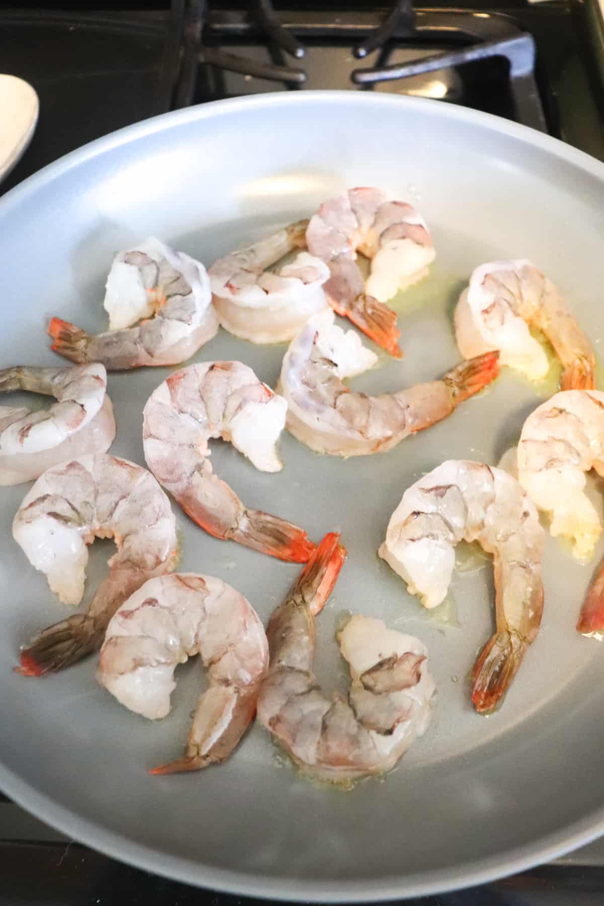 raw shrimp added to skillet.