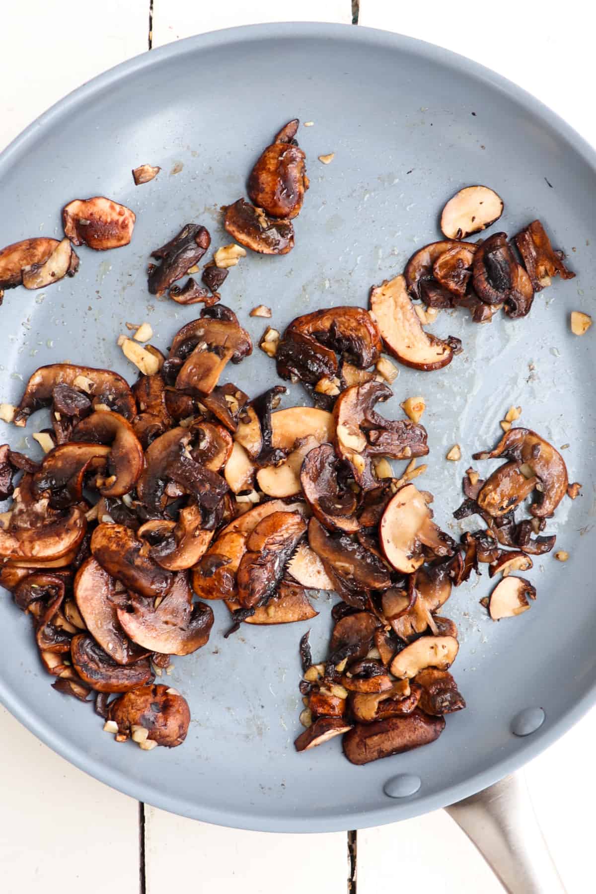 sauteed sliced mushrooms and garlic in pan.