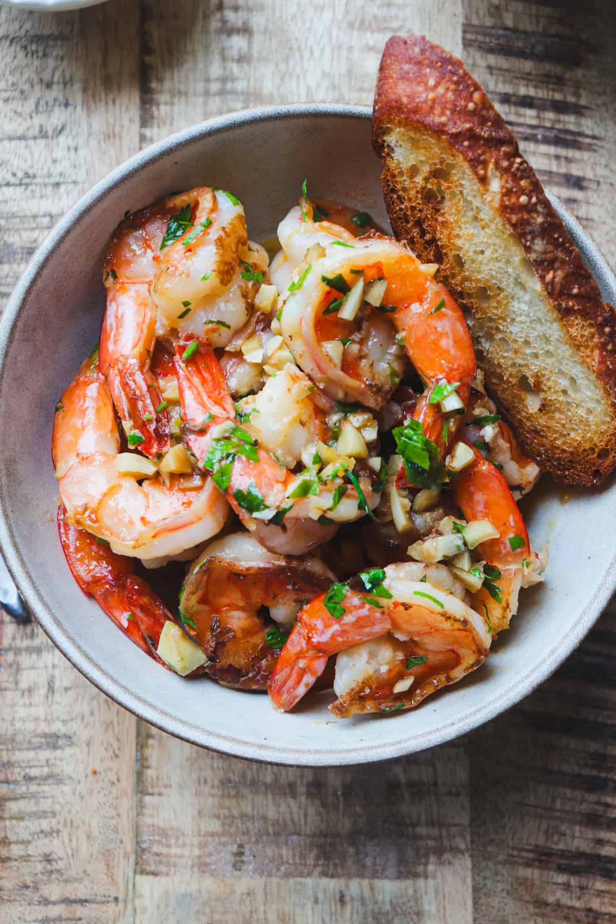 bowl of shrimp scampi with crusty bread.
