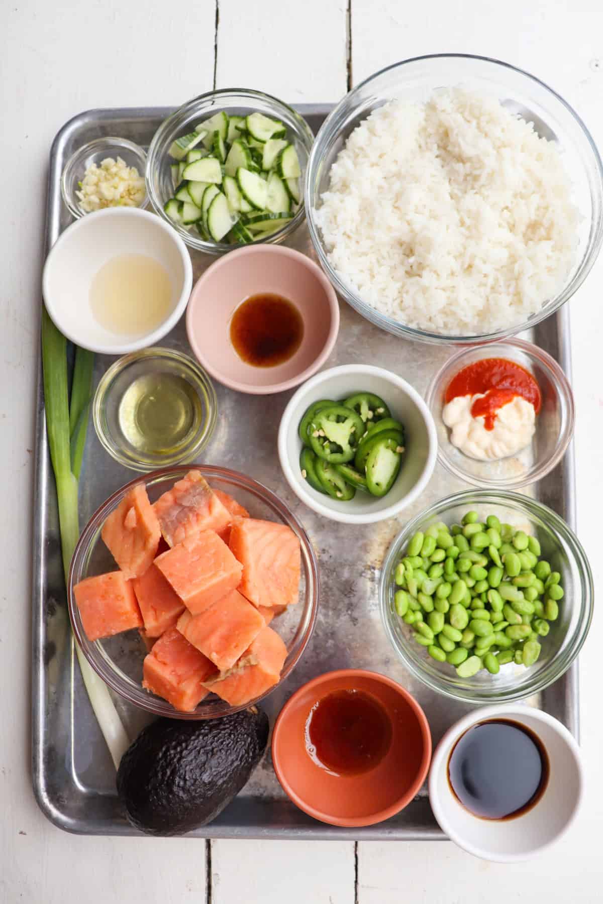 ingredients for cooked salmon poke bowls on a sheetpan.