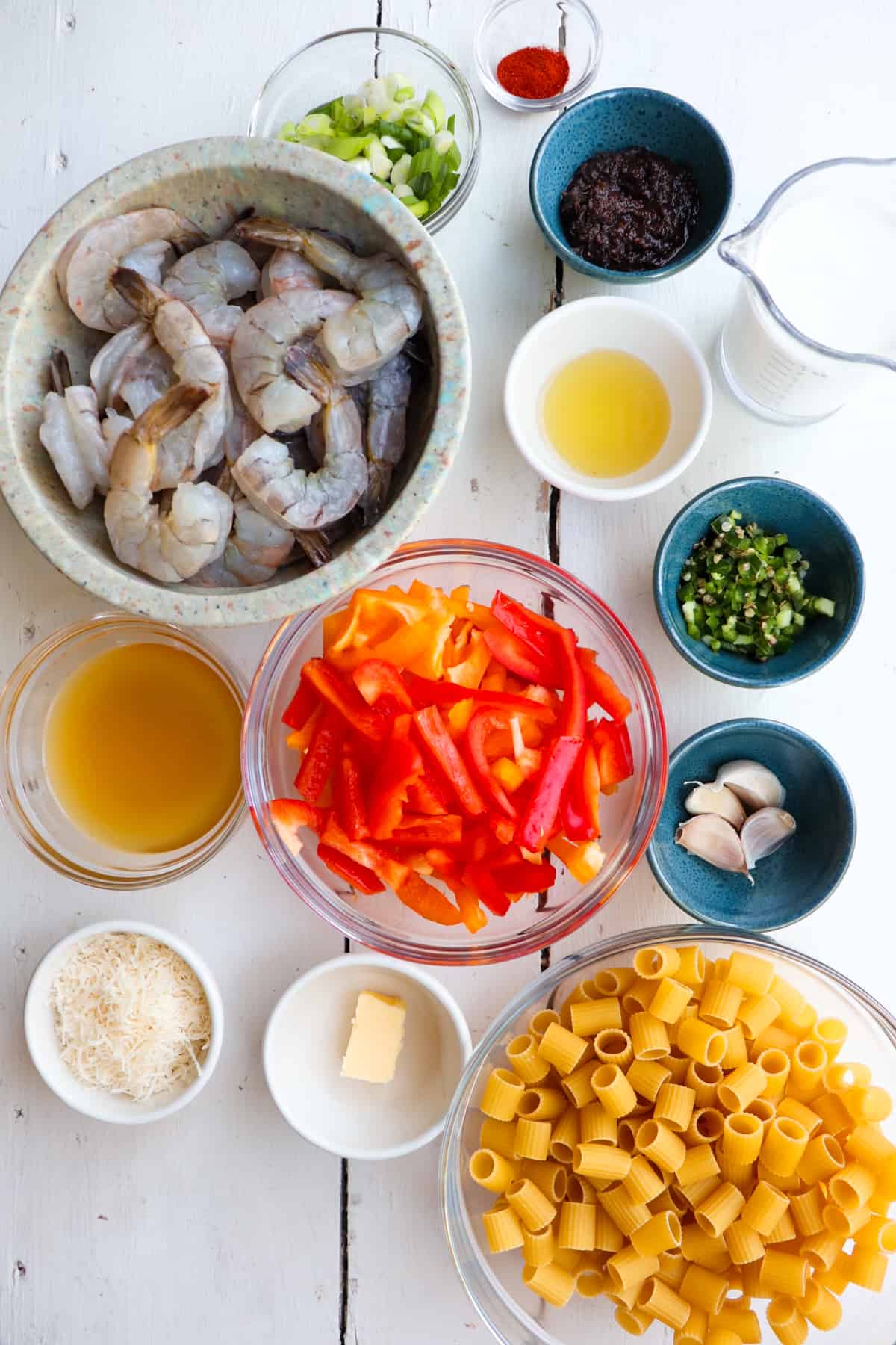 ingredients for jerk shrimp pasta on a white table.