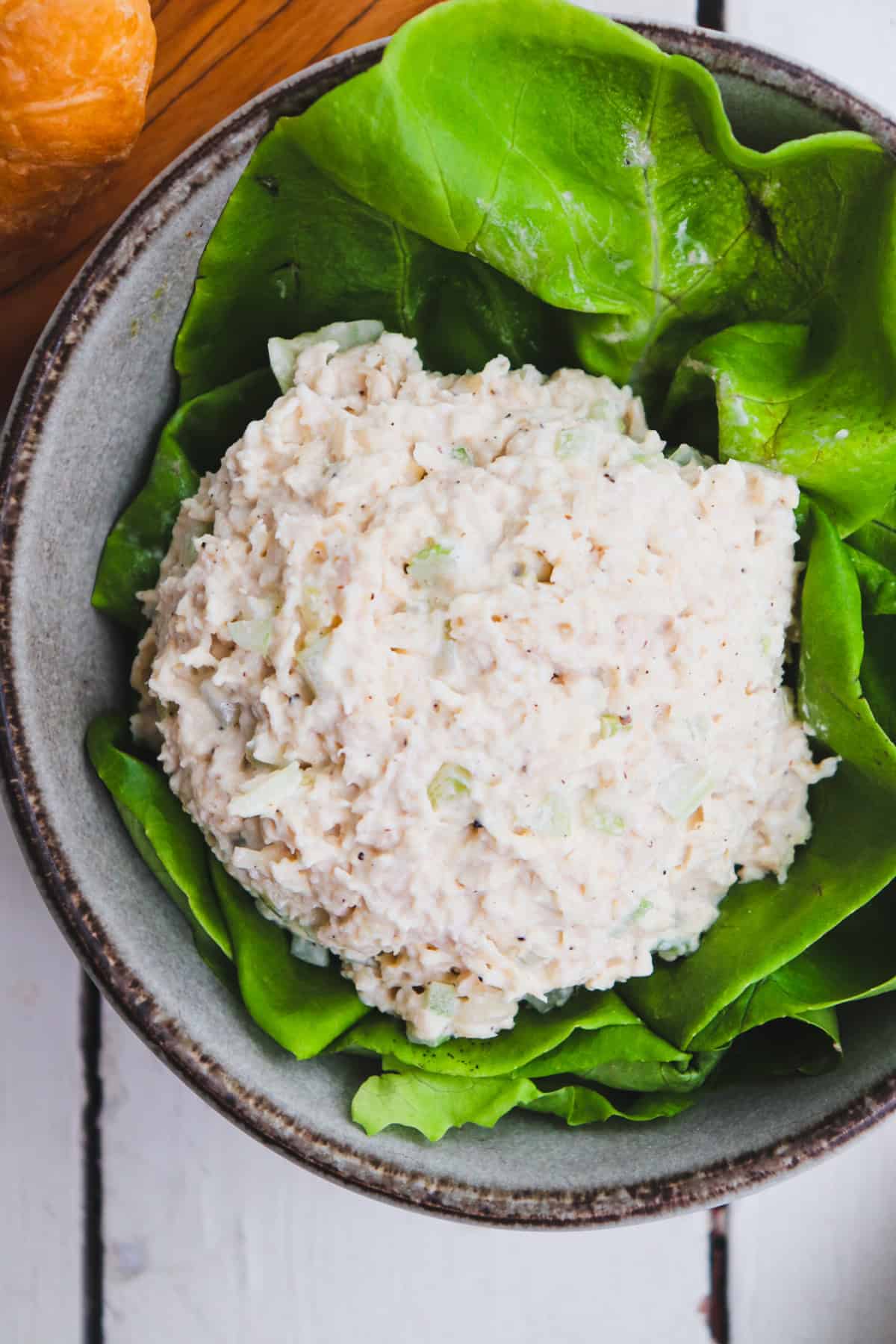 scoop of chicken salad in a bowl filled with lettuce.