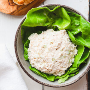 scoop of classic carol chicken salad in a bowl filled with lettuce.