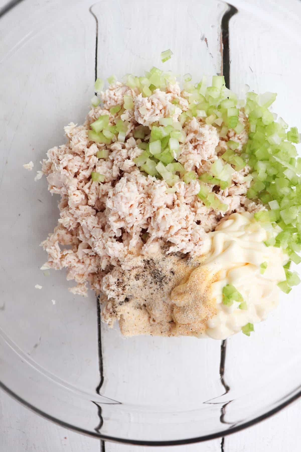 prepared ingredients for chicken salad in clear bowl unmixed.