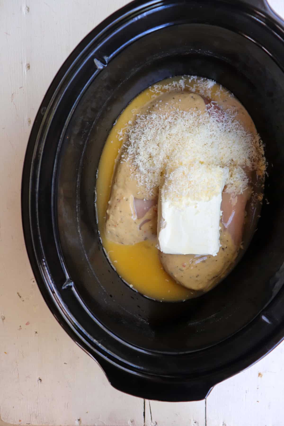 all ingredients added to a black crockpot. 