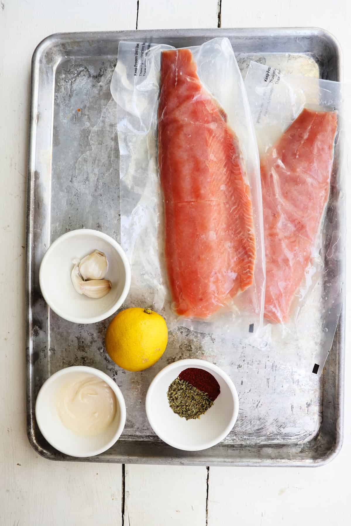 ingredients for mayonnaise salmon on a metal baking sheet.
