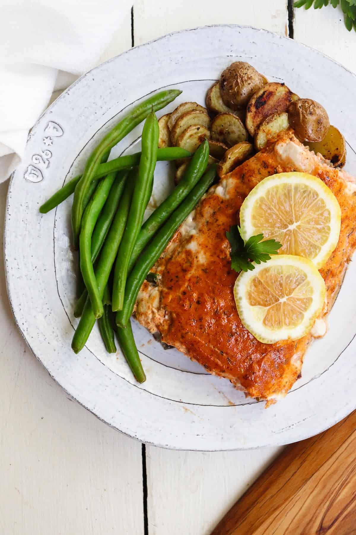 mayo baked salmon shown plated with green beans and potatoes.