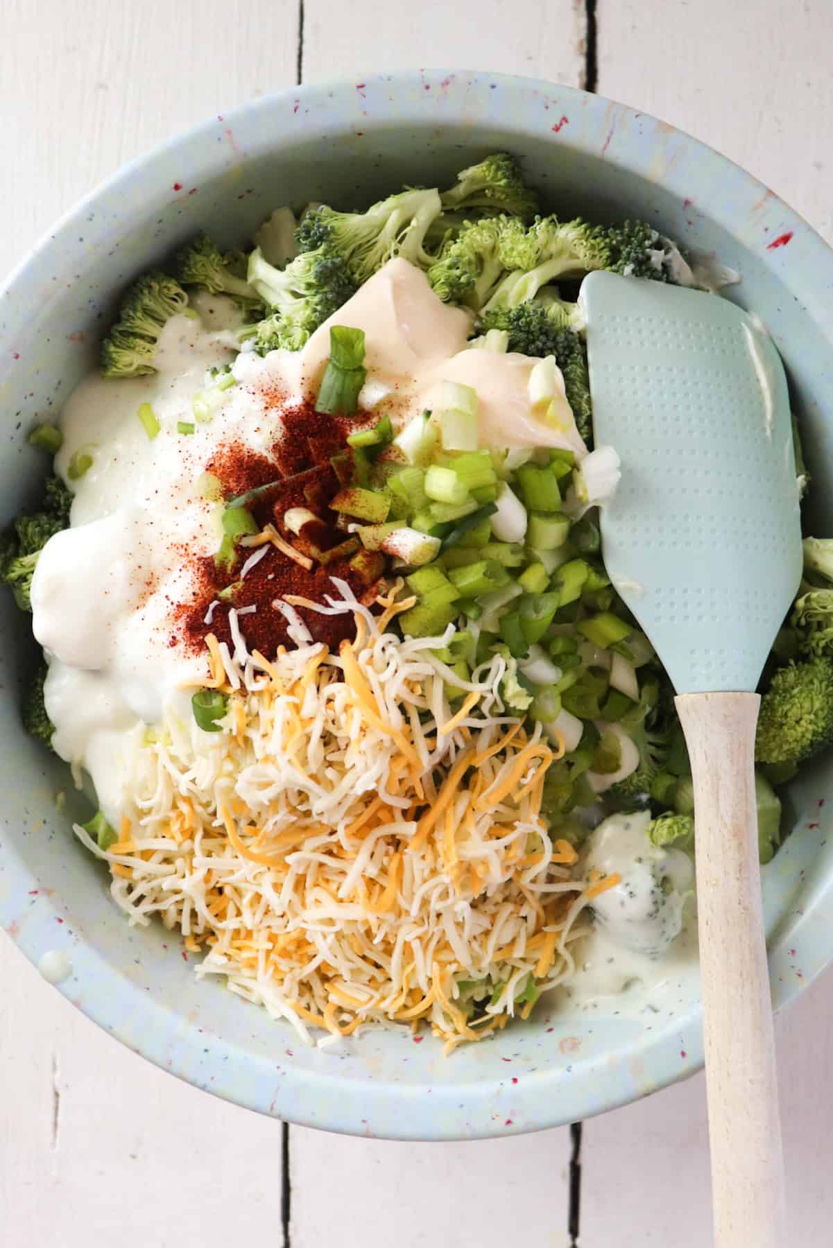 all ingredients for casserole added to a blue mixing bowl.