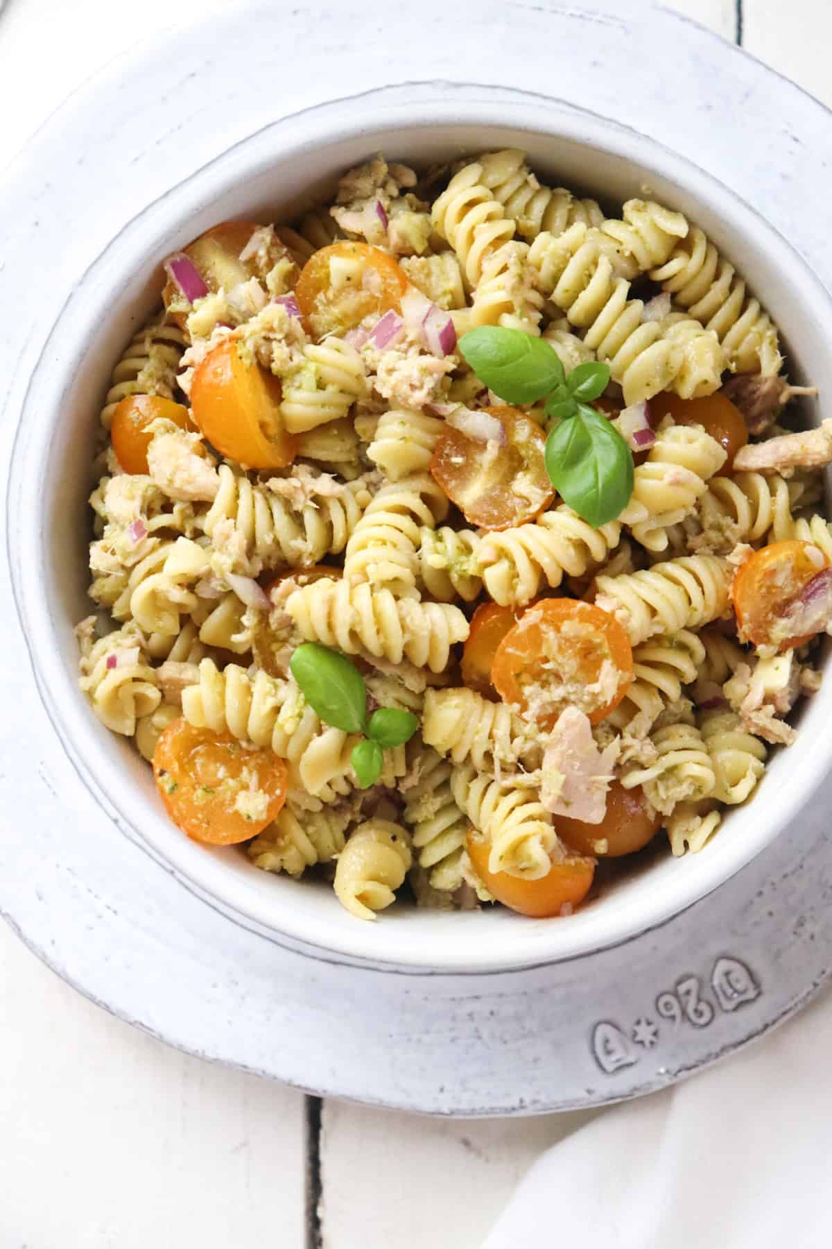 bowl of tuna pasta garnished with fresh basil.