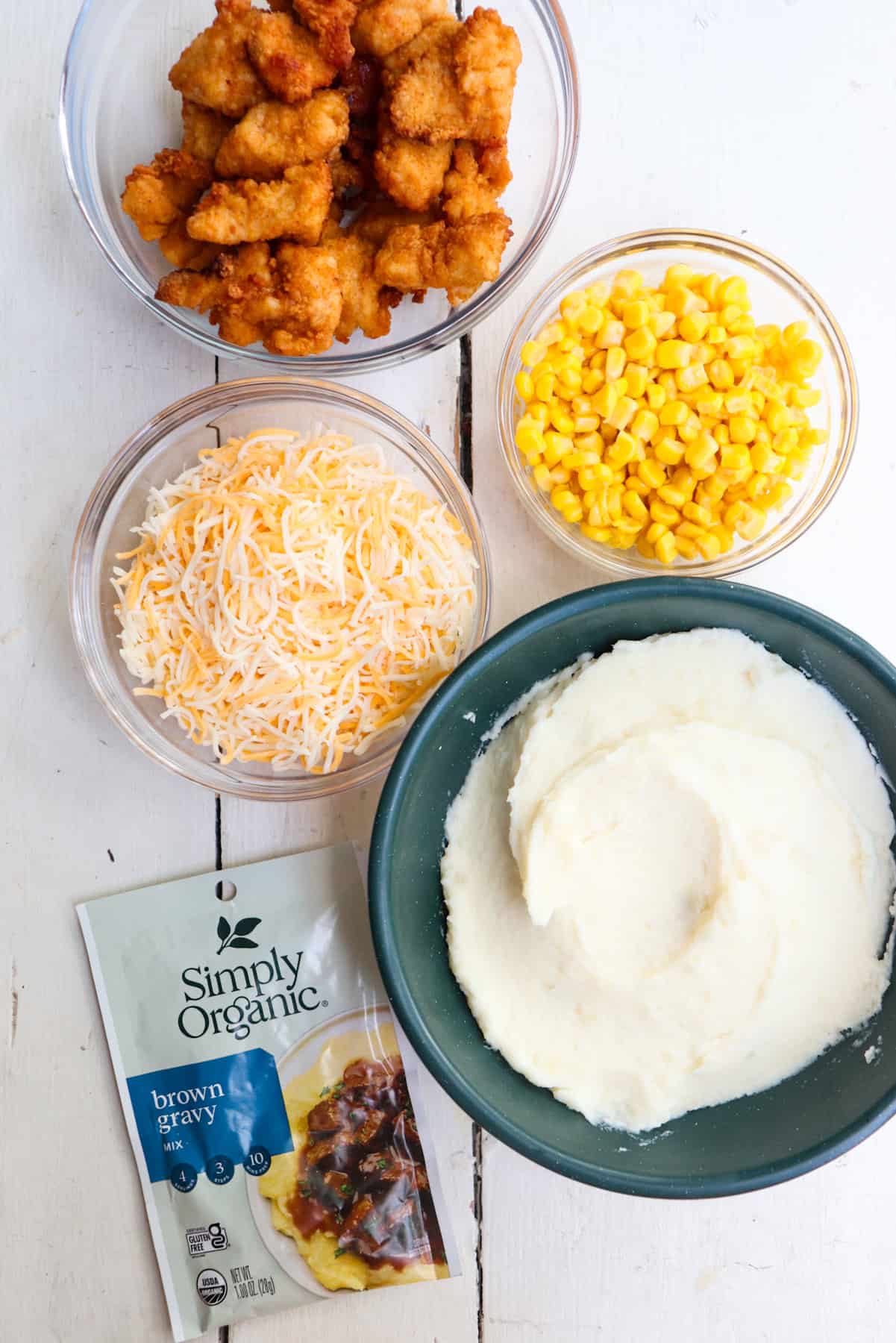 ingredients for at home kfc famous bowls on a white table.