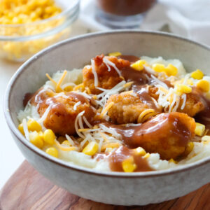 kfc famous bowl with ingredients in the background.