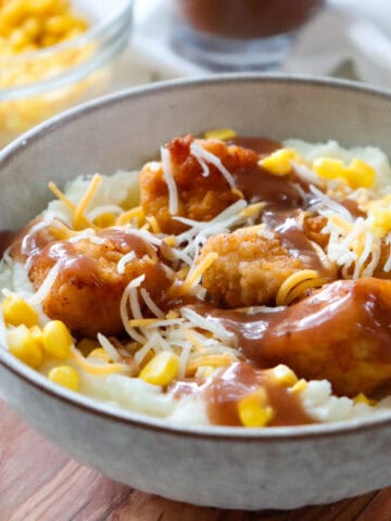 kfc famous bowl with ingredients in the background.