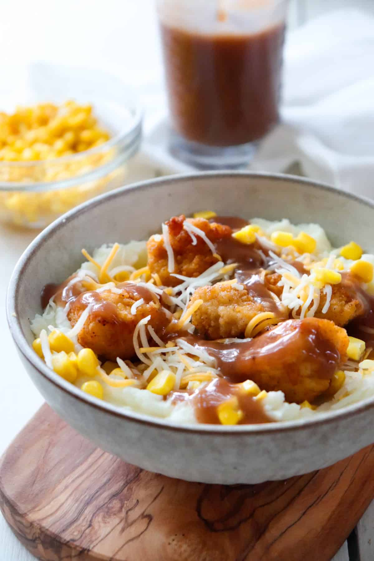 kfc famous bowl with ingredients in the background. 