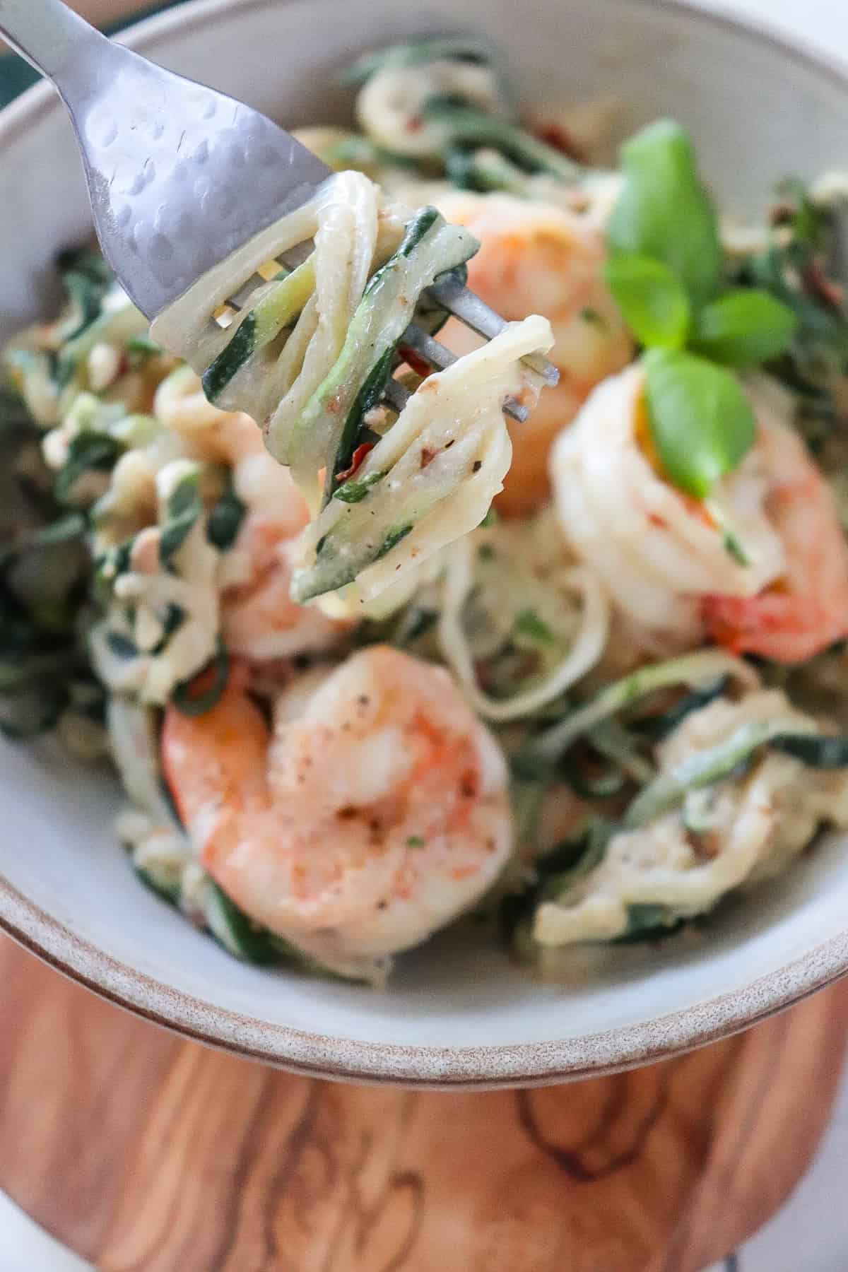 fork with a bite of zoodles coming from the bowl.