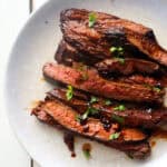 finished marinade steak sliced and on a white plate.