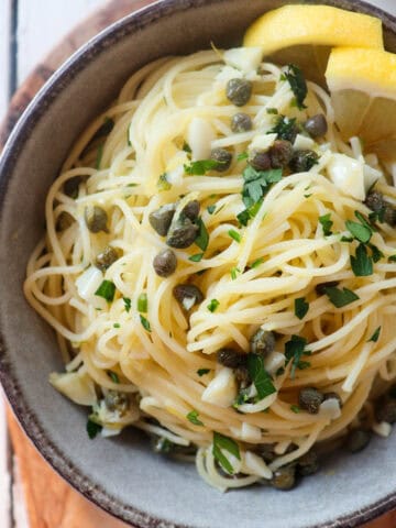 grey bowl filled with lemon caper pasta.