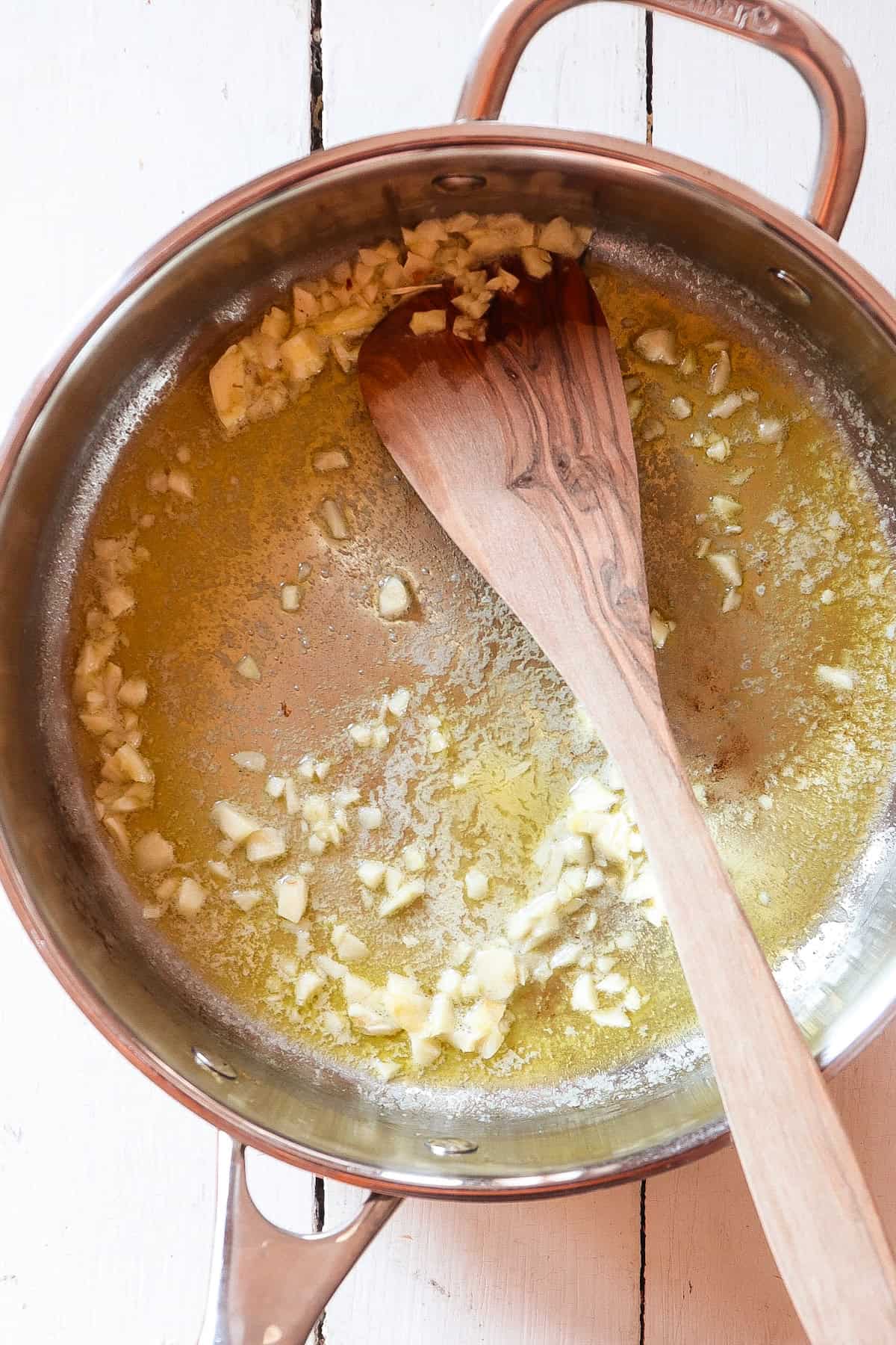 sauteed garlic in butter in a stainless steel pan.