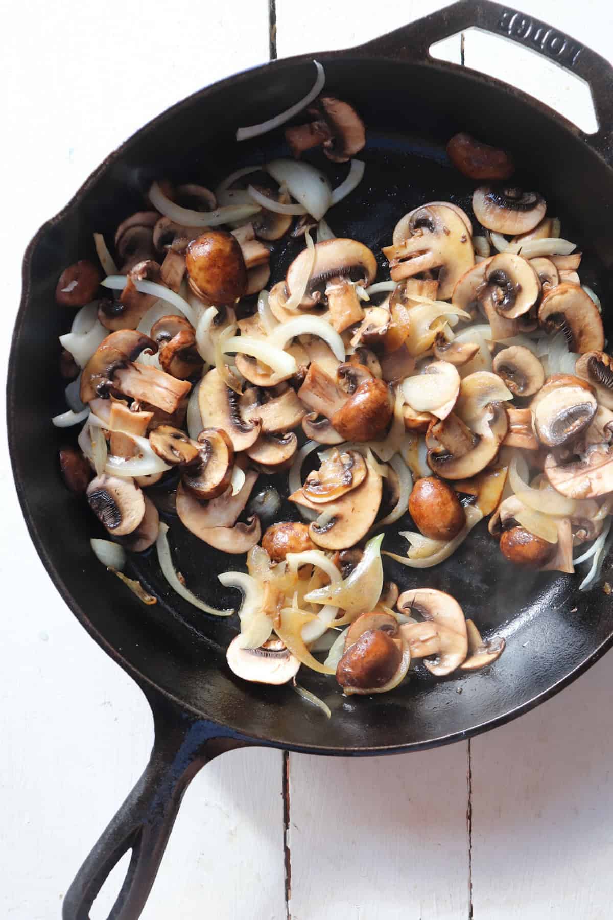 sauteed mushrooms and onions in a cast iron skillet.