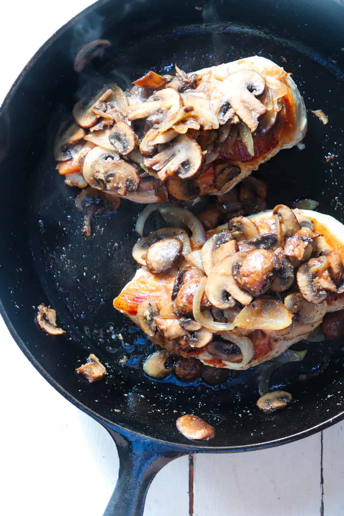 mushroom and onion mixture on top of cooked chicken breasts.