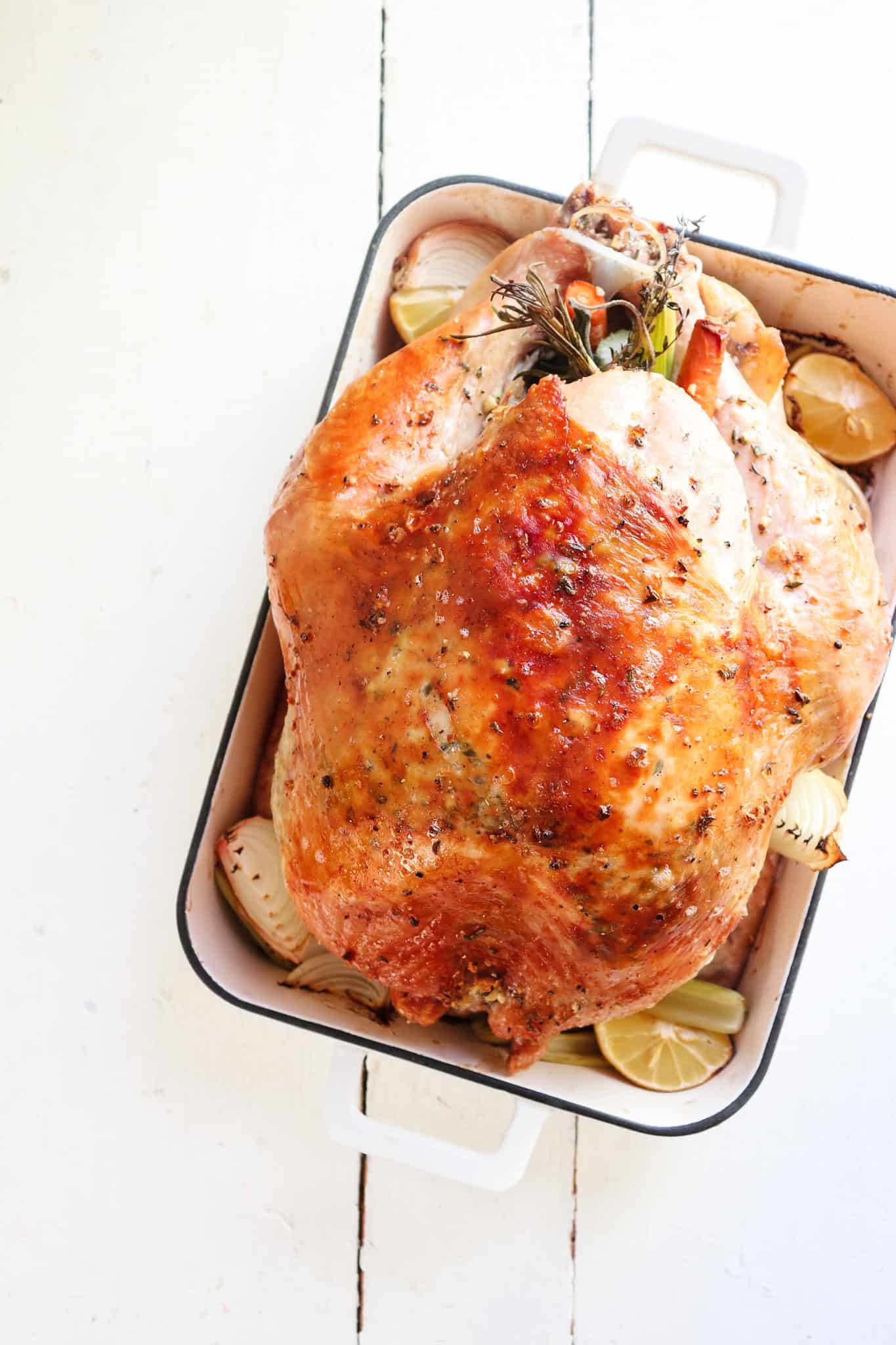 finished thanksgiving herb butter turkey in a roasting pan.