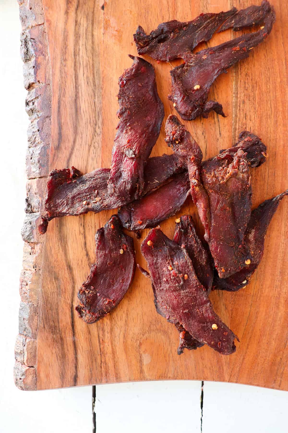 Cooked venison jerky on cutting board.