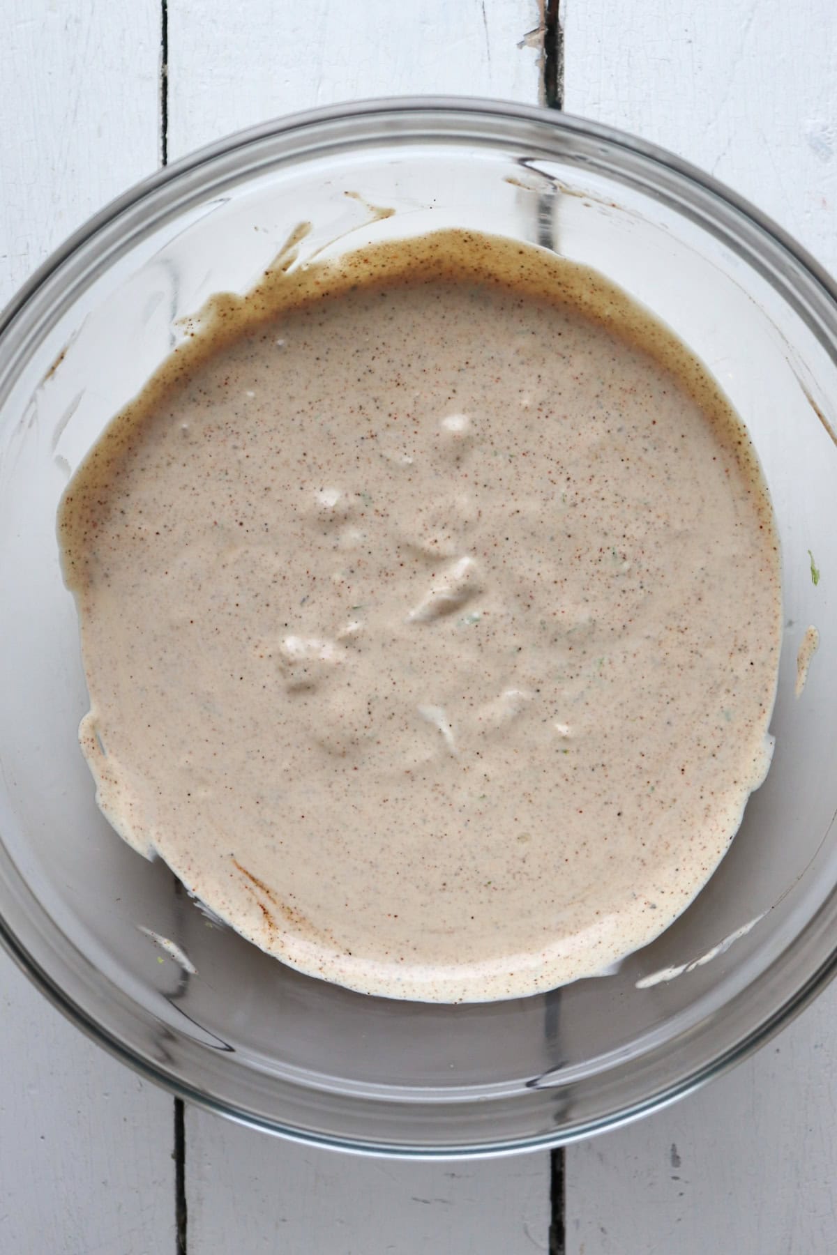 dressing ingredients for pasta salad in a clear glass bowl.