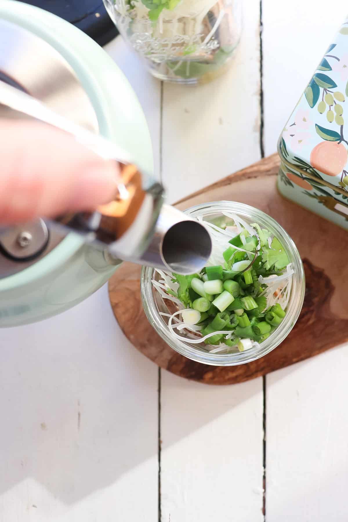 kettle pouring into mason jar noodle cup.