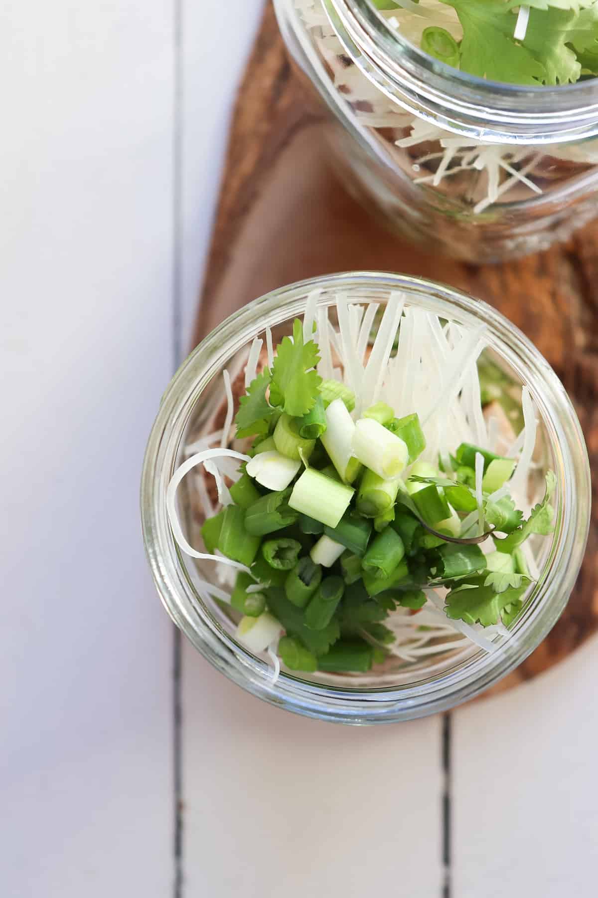 rice noodles and green onions in mason jar for noodle cup.