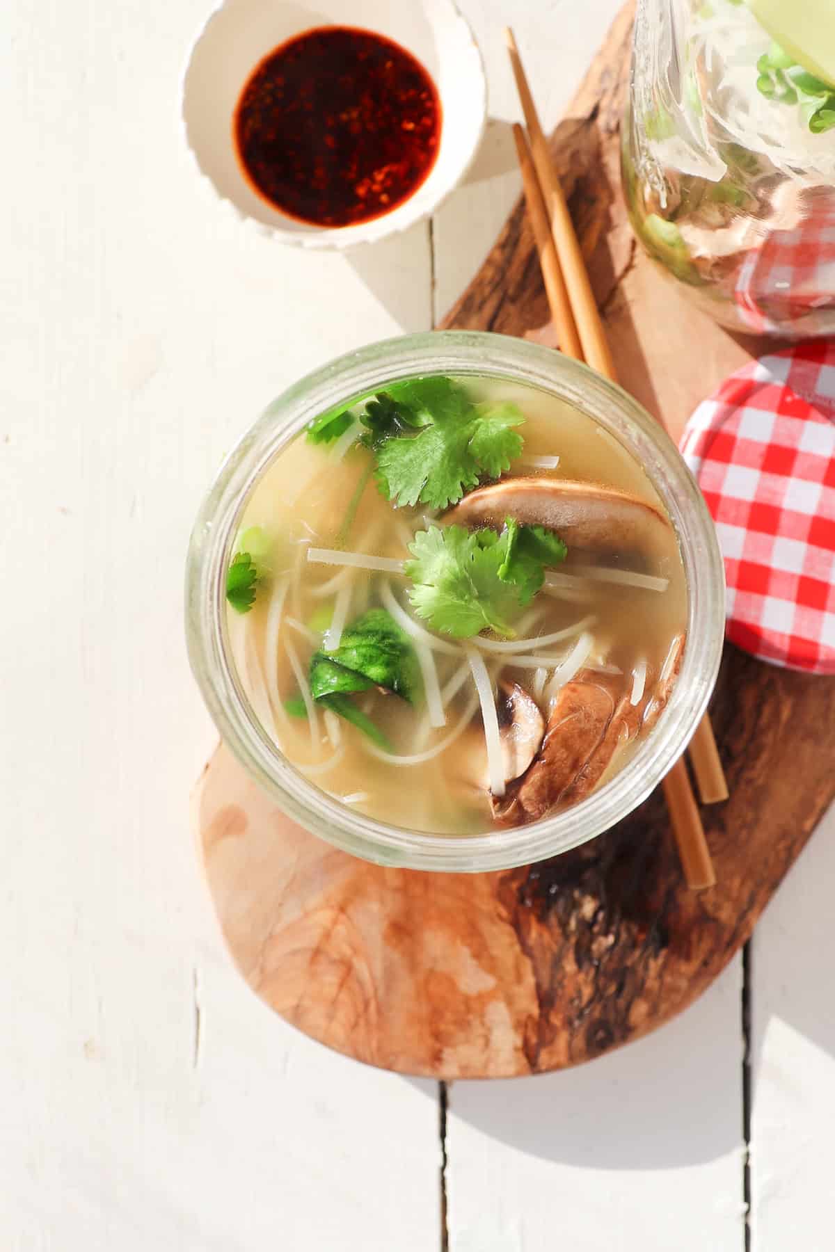 mason jar noodle cup with broth and ingredients.