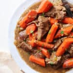 featured image for slow cooker venison roast shown up close on a white plate.