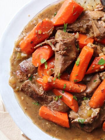 featured image for slow cooker venison roast shown up close on a white plate.